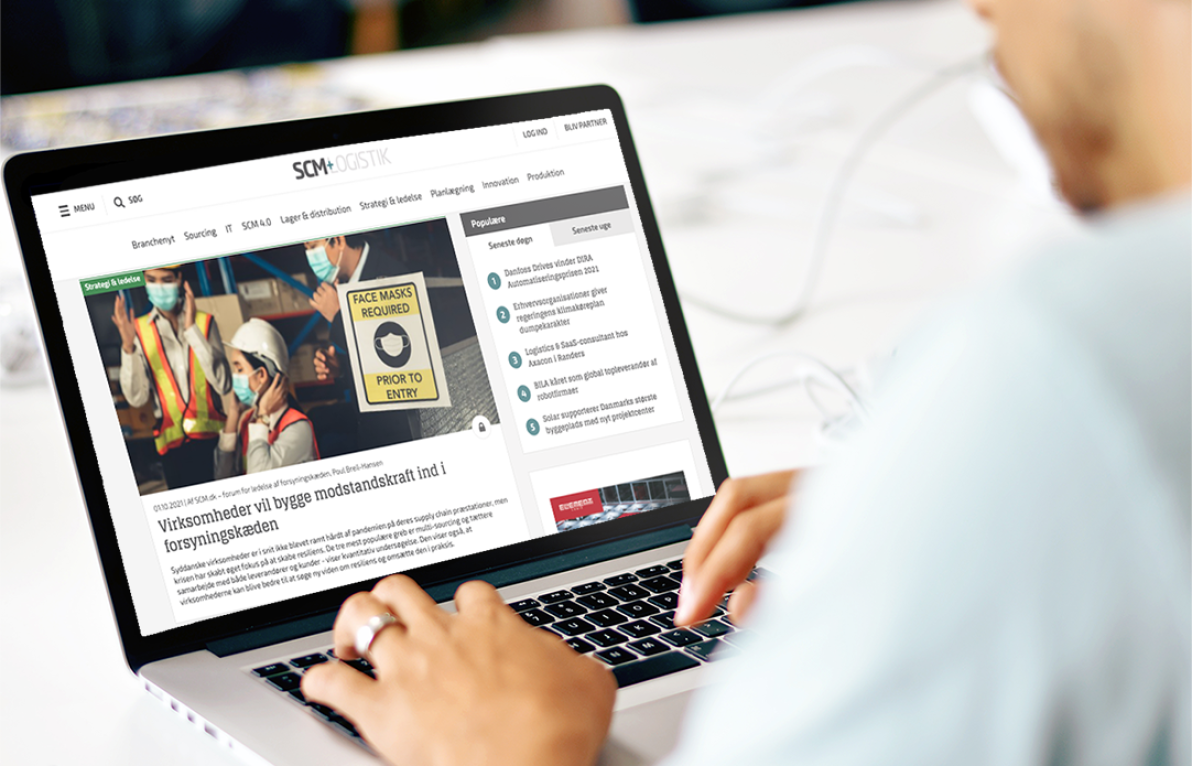Whitney leaning against a railing on a downtown street
